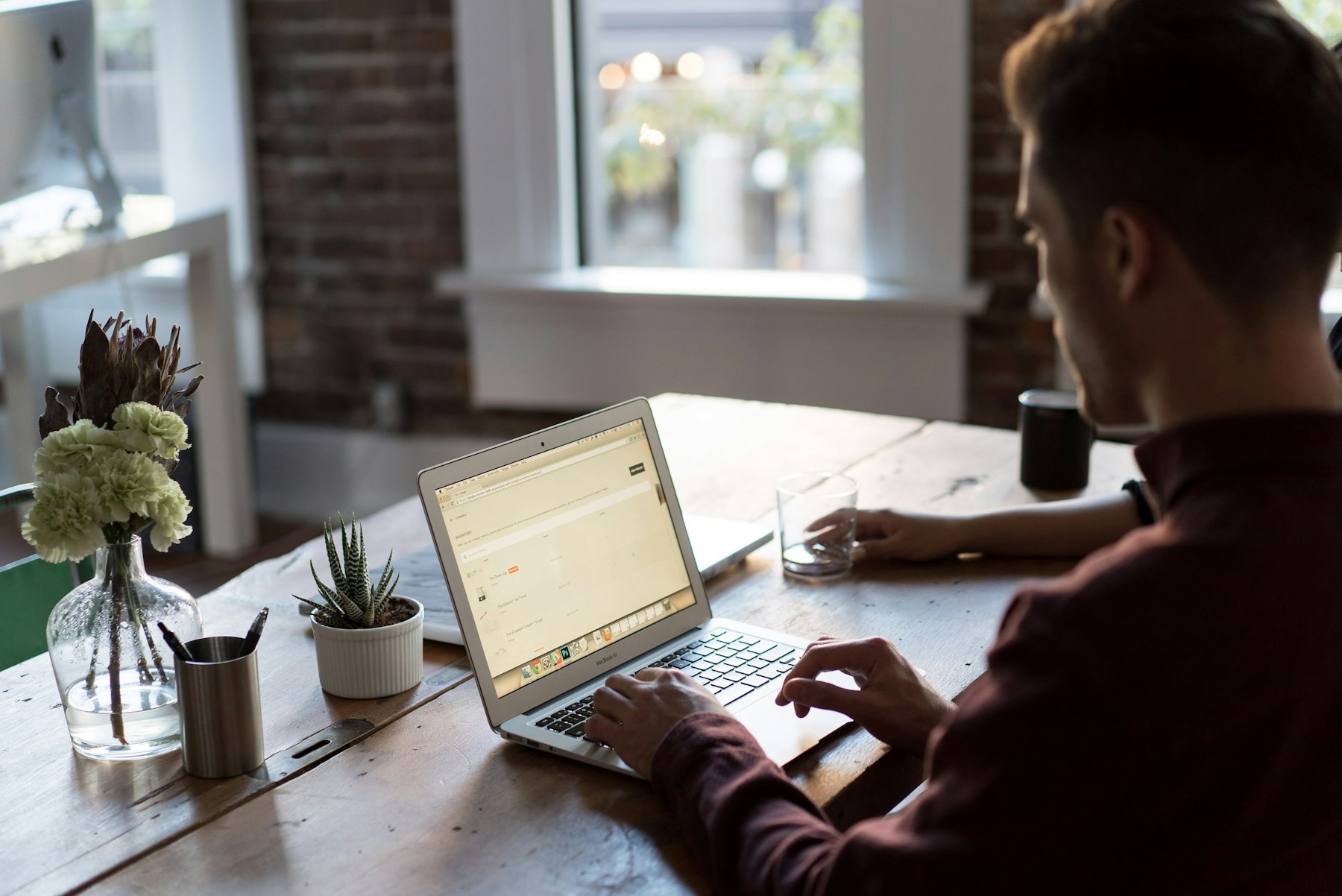 Developer working across two monitors in a bright loft